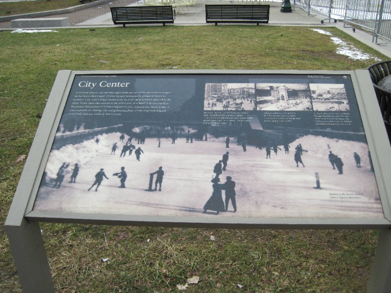 Syracuse012610-0166.jpg - Erie Canalway National Heritage Corridor.  City Center.At Clinton Square you can once again skate where earlier generations played on the frozen Erie Canal.Clinton Square has been the center of Syracuse business, civic, and cultural events since the first canal sections opened in the 1820s.In the 1920s this section of the Eric Canal was filled in to become Erie Boulevard. Renovation of Clinton Square in 2001 restored the opportunity to enjoy a public ice skating rink and gathering place.It also exposed original canal walls that are visible in front of you.